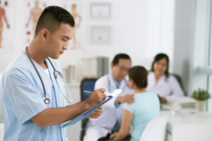 Medical assistant writing on paperwork on clipboard 