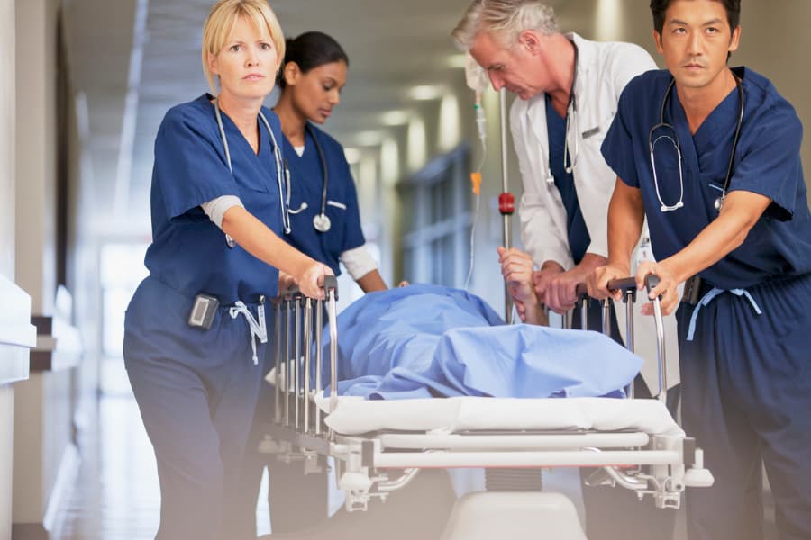 Medical professionals moving patient on stretcher 
