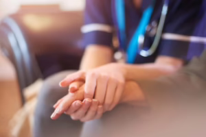 Nurse holding patient’s hand