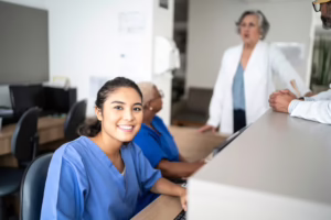 Nurse working at the nurse station at a hospital and smiling