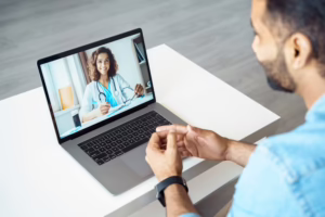 A man receives follow-up instructions from a medical assistant during a telemedicine appointment.