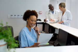 A medical assistant works at the front desk in a medical office.