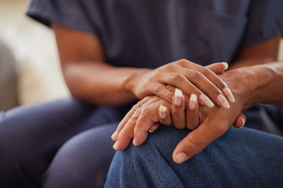 Medical assistant holds patient’s hands
