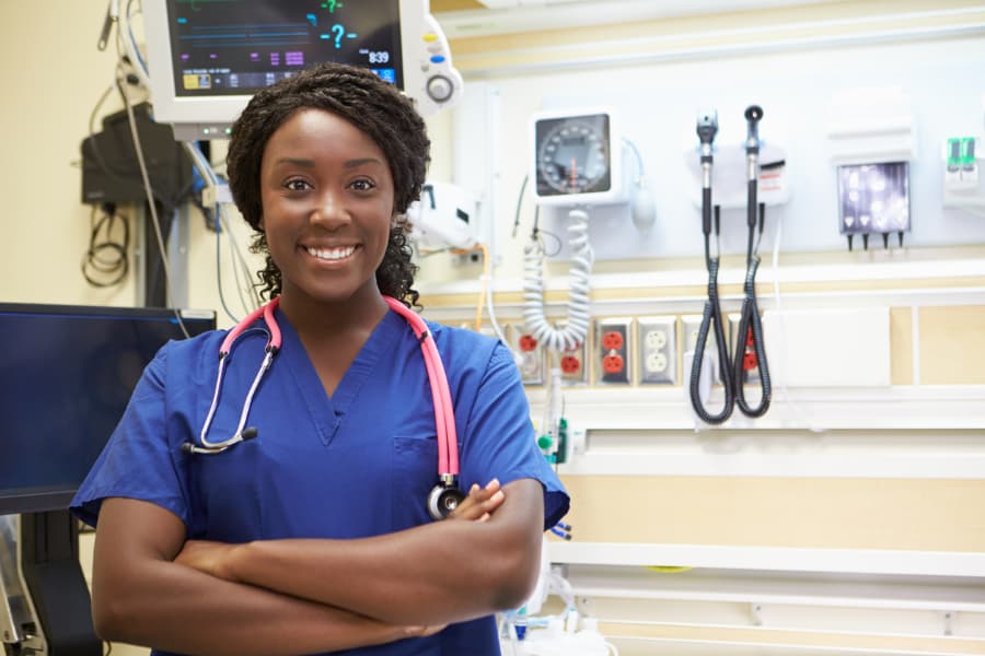 Nurse wearing blue scrubs in examination room at medical facility