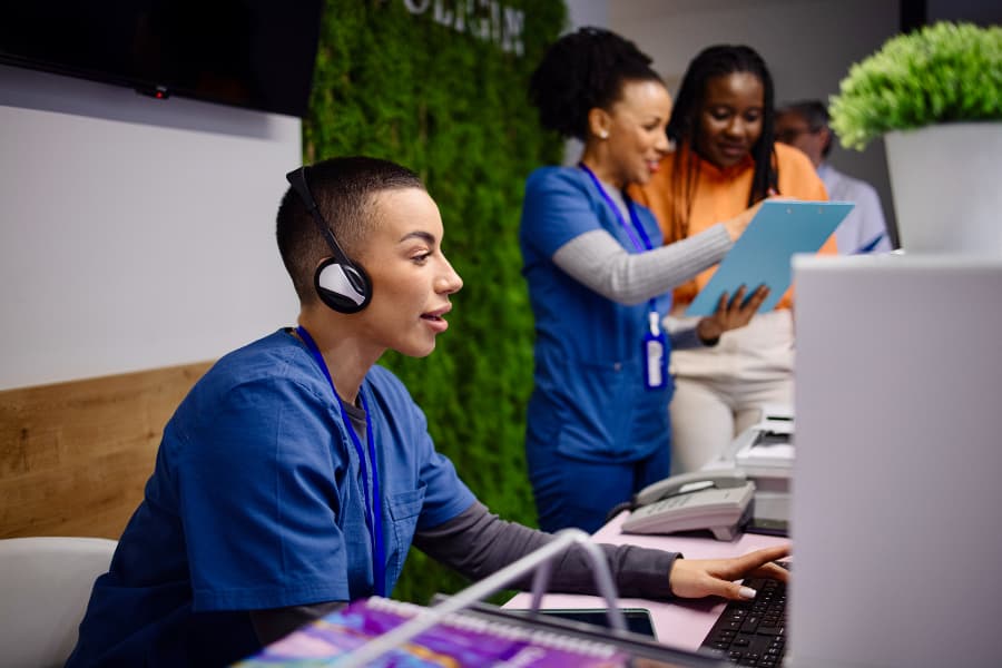 Medical assistant talking on telephone at hospital reception