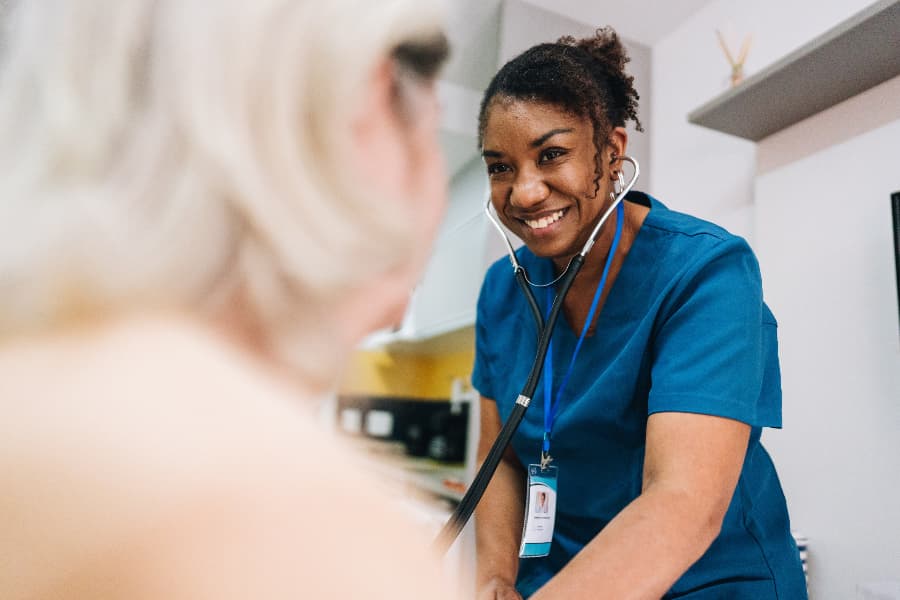 Nurse taking blood pressure of patient at home