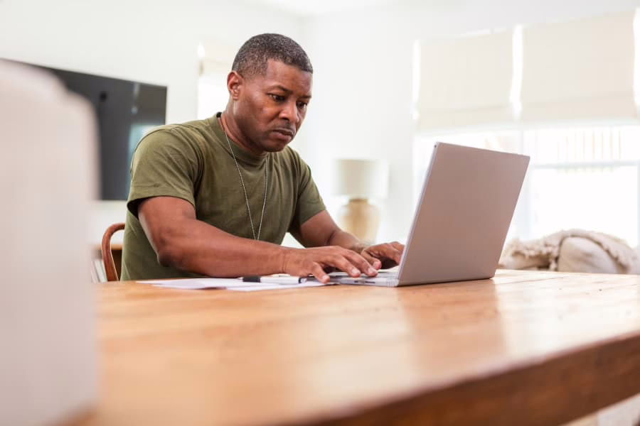 Military veteran seated at table using laptop