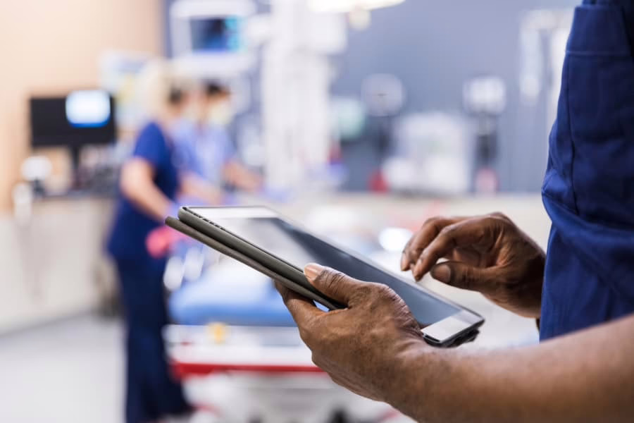 Healthcare professional viewing electronic medical records on tablet in procedure room 